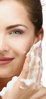 woman applying face wash to facial skin