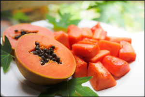 sweet papaya on the dish with green papaya leaf